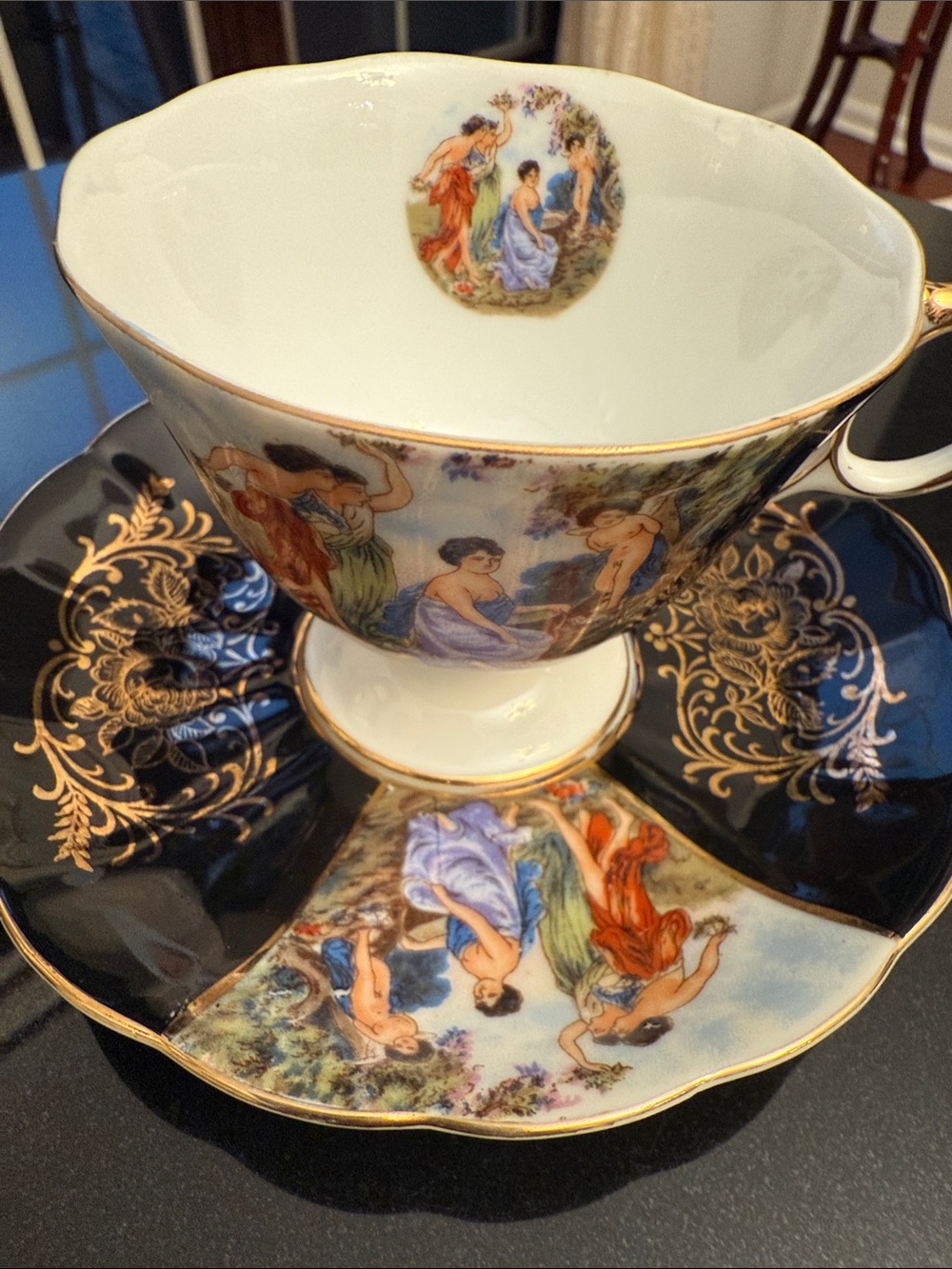 Elegant Porcelain Teacup and Saucer Set in Black and Gold with Classical Scene
